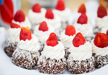 Image showing close up of rum cakes with custard and strawberry