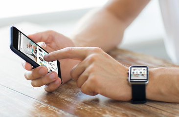 Image showing close up of hands with smart phone and watch