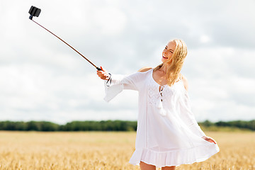 Image showing happy young woman taking selfie by smartphone