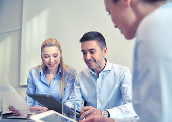 Image showing smiling businesspeople with tablet pc in office