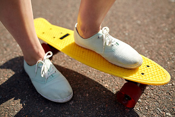 Image showing close up of female feet riding short skateboard