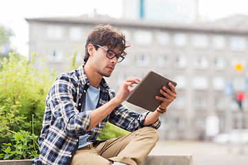 Image showing man with tablet pc sitting on city street bench