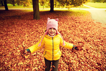 Image showing happy girl playing with autumn leaves in park