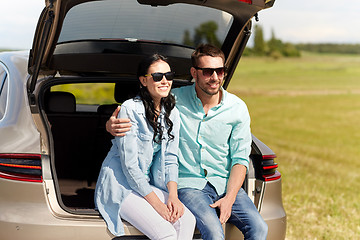 Image showing happy couple hugging at open hatchback car trunk