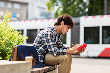 Image showing man with notebook or diary writing on city street