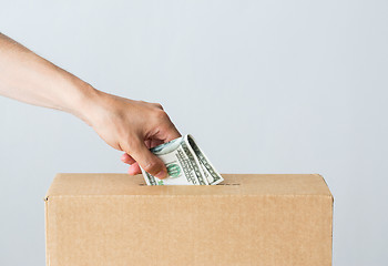 Image showing man putting dollar money into donation box