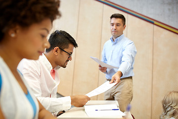 Image showing teacher giving tests to students at lecture