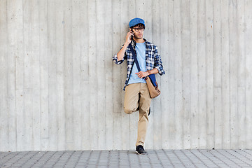 Image showing man with bag calling on smartphone at street wall