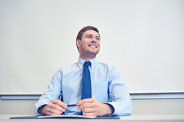Image showing smiling businessman sitting in office