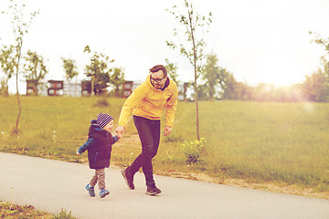 Image showing happy father and little son walking outdoors