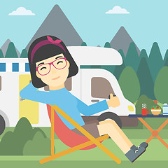 Image showing Woman sitting in chair in front of camper van.