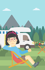 Image showing Woman sitting in chair in front of camper van.