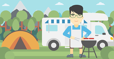 Image showing Man having barbecue in front of camper van.