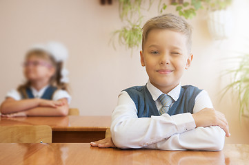 Image showing Happy schoolboy sitting at desk