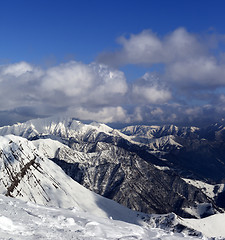 Image showing Sunlit mountains in clouds, view from off-piste slope