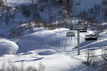 Image showing Chair-lift and off-piste slope in winter day