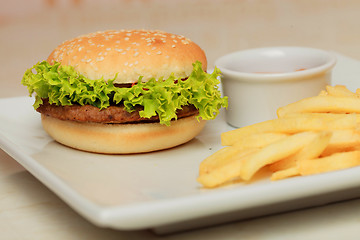 Image showing classic burger with French fries on the table in a cafe