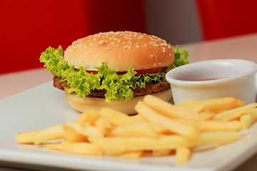 Image showing classic burger with French fries on the table in a cafe