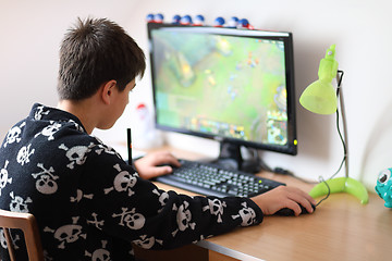 Image showing Boy using computer at home, playing game