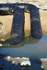 Image showing two balck metal pipes going into the river