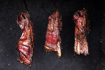 Image showing Smoking pork neck in home smokehouse