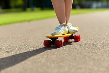 Image showing close up of female feet riding short skateboard