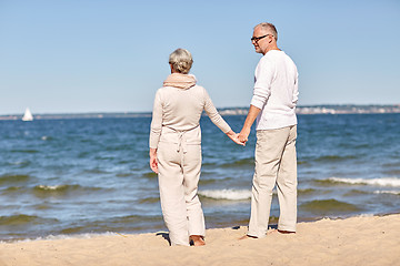 Image showing happy senior couple holding hands summer beach