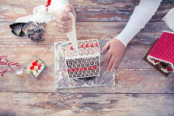 Image showing close up of woman making gingerbread houses