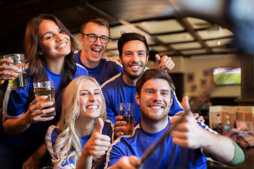 Image showing football fans with beer taking selfie at pub