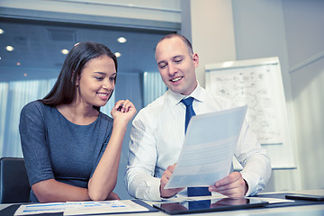 Image showing smiling businesspeople with papers in office