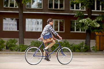 Image showing young hipster man with bag riding fixed gear bike