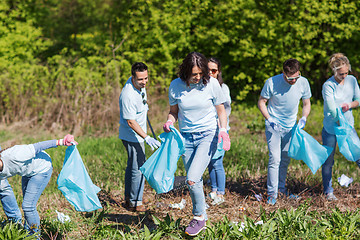 Image showing volunteers with garbage bags cleaning park area