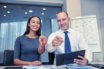 Image showing smiling businesspeople with tablet pc in office