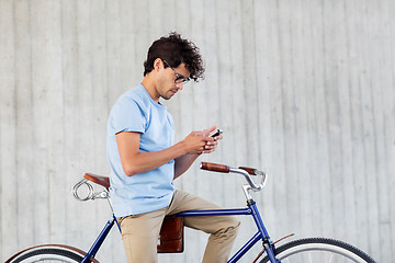 Image showing man with smartphone and fixed gear bike on street