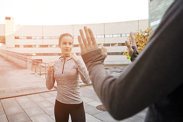 Image showing woman with trainer working out self defense strike