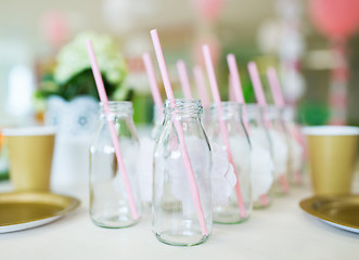 Image showing close up of glass bottles for drinks with straws