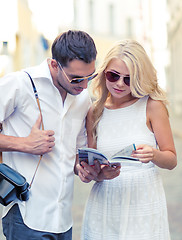 Image showing couple with map, camera and travellers guide