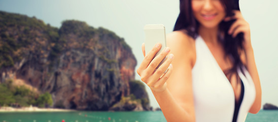 Image showing young woman taking selfie with smartphone on beach