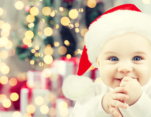 Image showing happy baby in santa hat over christmas lights