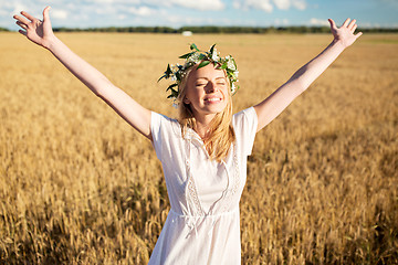 Image showing happy young woman in flower wreath on cereal field