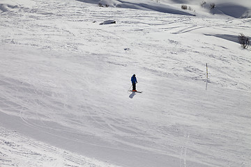 Image showing Skier on ski slope at sun winter evening