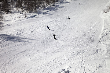 Image showing Skiers and snowboarders on ski slope at sun winter day