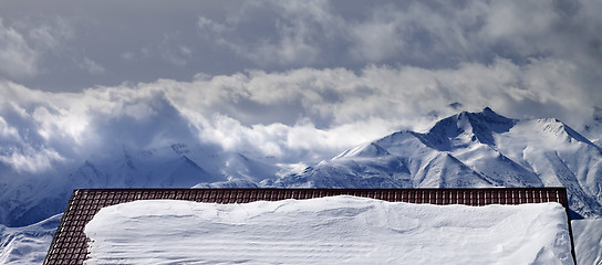 Image showing Panoramic view on snowy roof and mountains in clouds