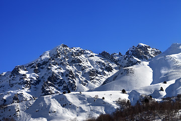 Image showing Snowy rocks and off-piste slope in sunny morning