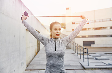 Image showing woman exercising with jump-rope outdoors