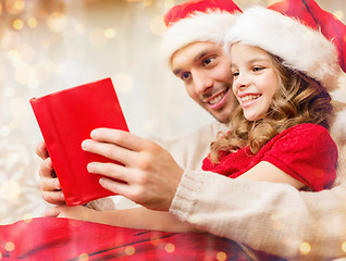 Image showing smiling father and daughter reading book