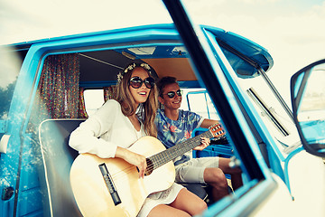Image showing smiling hippie couple with guitar in minivan car
