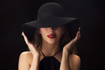 Image showing beautiful woman in black hat over dark background