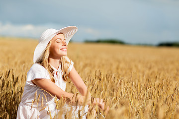 Image showing happy young woman in sun hat on cereal field