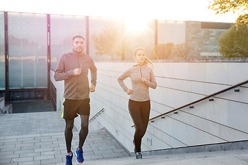 Image showing happy couple running upstairs on city stairs